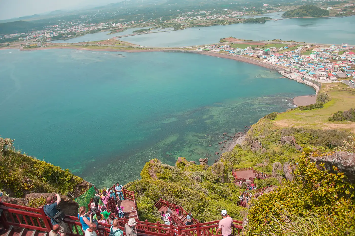 View from Seongsan Ilchulbong over the Jeju coastline and a turquoise bay